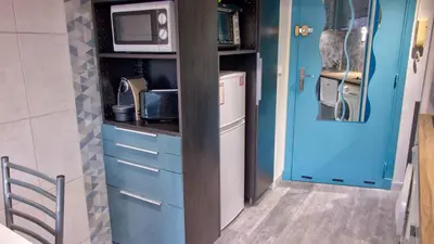 a small kitchen with blue cabinets and a microwave at 3 StarsStudio54 23 Ave Laugier100m Plages Mistral in Cannes