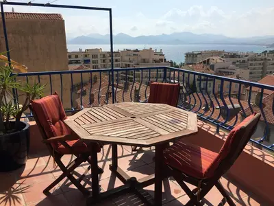 a wooden table and two chairs on a balcony at les terrasses du Suquet in Cannes