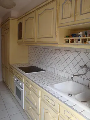 a kitchen with yellow cabinets and a white sink at les terrasses du Suquet in Cannes