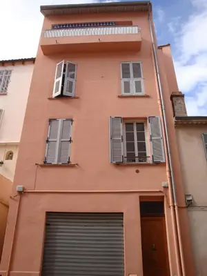 a orange building with windows and a garage at les terrasses du Suquet in Cannes