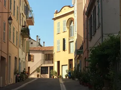 an empty street in an alley between two buildings at les terrasses du Suquet in Cannes