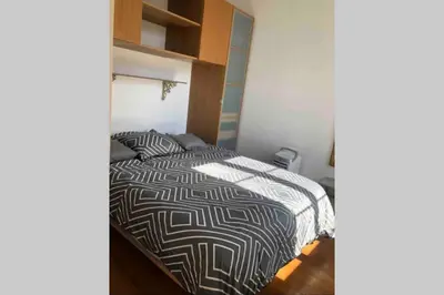 a bedroom with a bed with a black and white comforter at Bel appartement bien placé au cœur de Cannes in Cannes