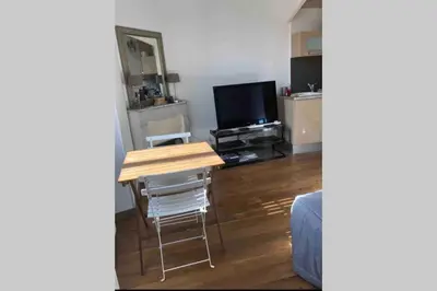 a living room with a table and a television at Bel appartement bien placé au cœur de Cannes in Cannes