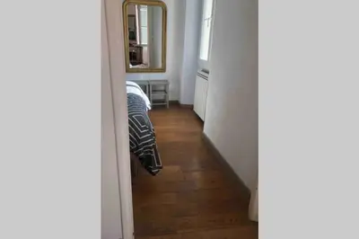 a room with a hallway with a bed and a mirror at Bel appartement bien placé au cœur de Cannes in Cannes
