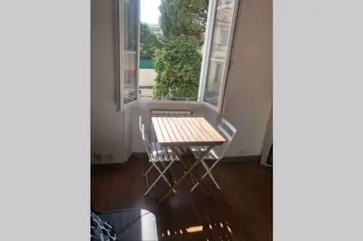 a table and a chair in front of a window at Bel appartement bien placé au cœur de Cannes in Cannes