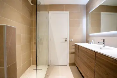 a bathroom with a sink and a glass shower at 2-Bedroom apartment in Grand Hotel in Cannes