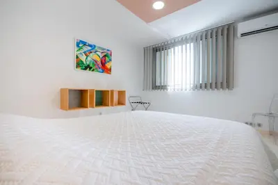 a white bedroom with a large white bed at 2-Bedroom apartment in Grand Hotel in Cannes