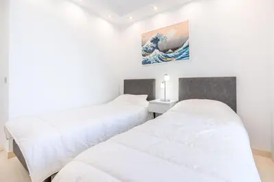 two beds in a room with a wave on the wall at 2-Bedroom apartment in Grand Hotel in Cannes