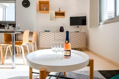 a bottle of champagne on a white table in a living room at 2-Bedroom apartment in Grand Hotel in Cannes