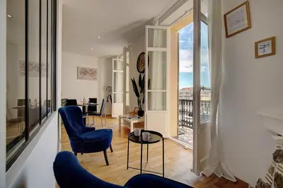 a living room with blue chairs and a balcony at Le ART - 500m des plages - Clim - Verrière Côte d'Azur in Cannes