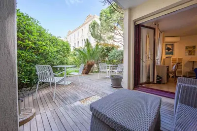 a patio with chairs and a table on a deck at Paradise Cannes Center with Pool and Park VILLA LE LYS in Cannes