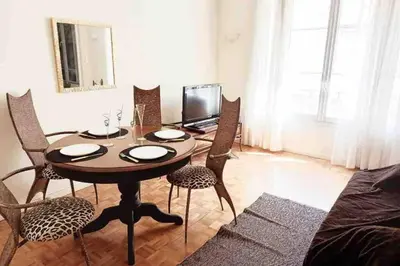 a dining room table with chairs and a laptop on it at Appartement hyper-centre Croisette Cannes in Cannes