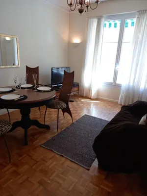 a living room with a dining room table and chairs at Appartement hyper-centre Croisette Cannes in Cannes