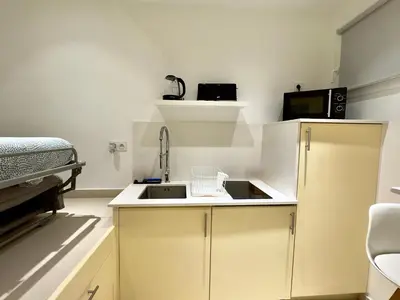 a small kitchen with a sink and a bed at Le Barri By SCLS Locations in Cannes