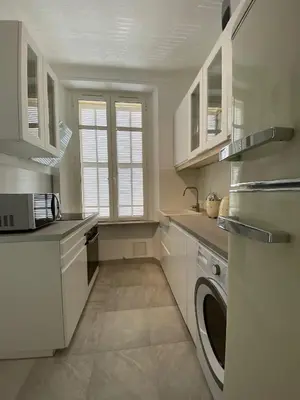 a kitchen with white cabinets and a washer and dryer at Beautiful Apartment 2mn walking distance from La Croisette and The Beach in Cannes