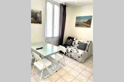 a living room with a glass table and a chair at Bel Appartement - HYPER CENTRE - 2 pièces in Cannes
