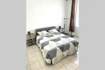 a bedroom with a bed with a black and white comforter at Bel Appartement - HYPER CENTRE - 2 pièces in Cannes