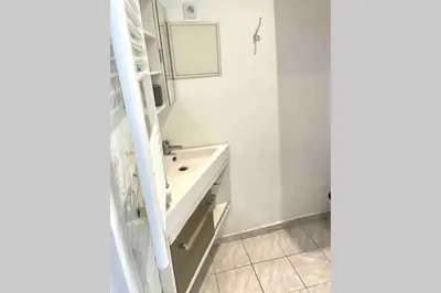a white bathroom with a sink and a mirror at Bel Appartement - HYPER CENTRE - 2 pièces in Cannes