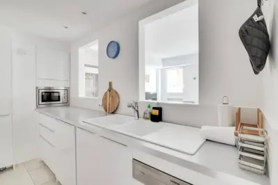 a white kitchen with white cabinets and a sink at C066-Luxurious apartment with sea view - Cannes in Cannes