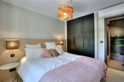 a bedroom with a large white bed with a pink blanket at Luxury flat with balcony - city center Cannes in Cannes