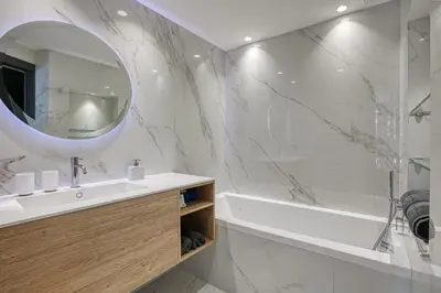 a bathroom with a sink and a tub and a mirror at Luxury flat with balcony - city center Cannes in Cannes