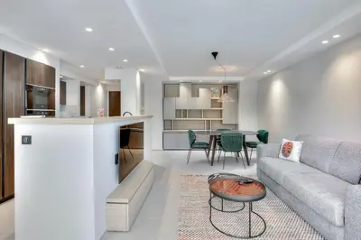 a living room and kitchen with a couch and a table at Luxury flat with balcony - city center Cannes in Cannes