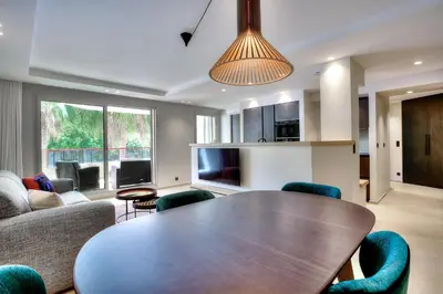 a living room with a wooden table and chairs at Luxury flat with balcony - city center Cannes in Cannes