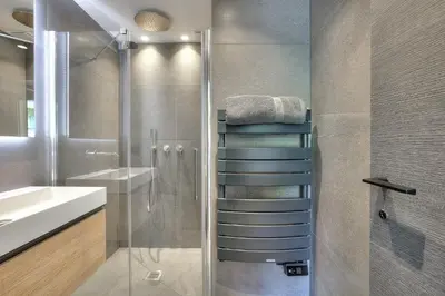 a bathroom with a shower and a stack of towels at Luxury flat with balcony - city center Cannes in Cannes