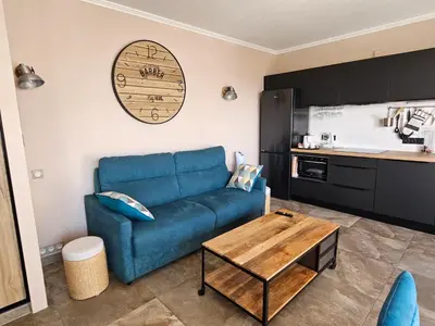 a living room with a blue couch and a table at Cannes President vue mer, festival, quartier forville le Suquet in Cannes
