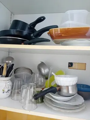 a shelf filled with dishes and utensils at Private room full furnished in cannes in Cannes