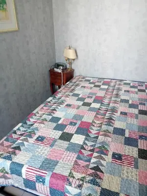 a bed with a quilt on it in a bedroom at Private room full furnished in cannes in Cannes