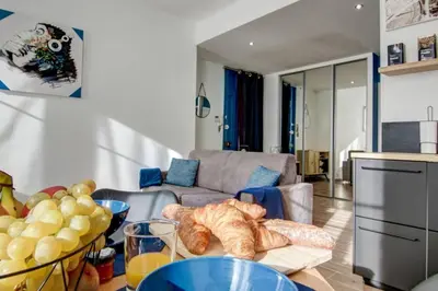 a living room with a couch and a table with bread at Palais Apartment in Cannes
