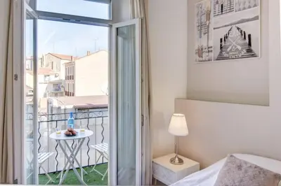 a bedroom with a balcony with a bed and a window at Palais Apartment in Cannes