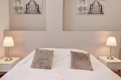 a bedroom with a white bed with two lamps at Palais Apartment in Cannes