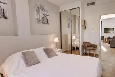 a bedroom with a white bed with two pillows on it at Palais Apartment in Cannes