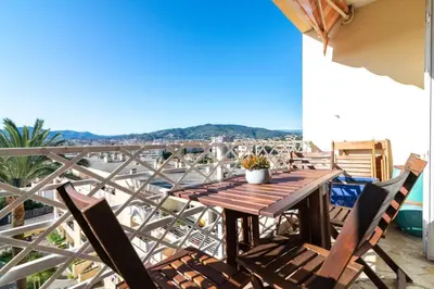 a wooden table and chairs on a balcony with a view at C078-Superb apt in Cannes - Sea view - 6 people in Cannes