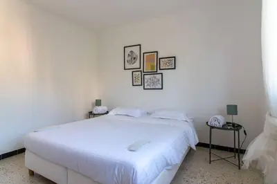 a white bedroom with a white bed and pictures on the wall at C078-Superb apt in Cannes - Sea view - 6 people in Cannes
