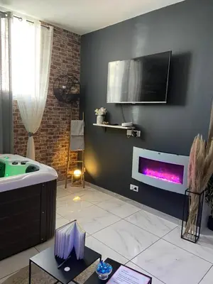 a living room with a tub and a tv on the wall at Nuit privée in Cannes