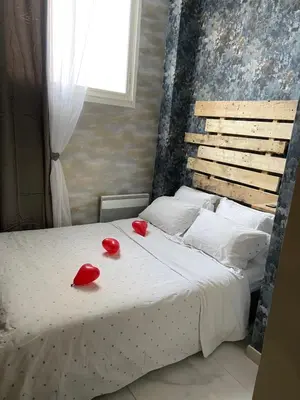 a bed with two red shoes on top of it at Nuit privée in Cannes