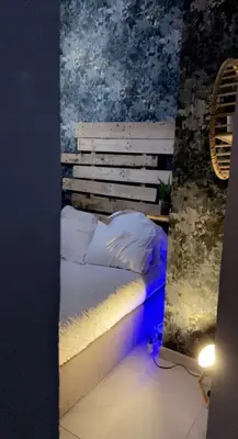 a bedroom with a bed with a blue light at Nuit privée in Cannes