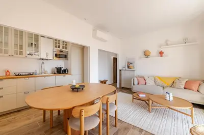 a kitchen and a living room with a table and a couch at Splendide 80m2 - 2 Chambres - 5,10min Plages & Gare & Palais des Festivals - Air conditionné in Cannes