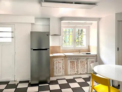 a kitchen with a refrigerator and a table at VILLA ARVOR CANNES Appartement indépendant en bas de maison in Cannes