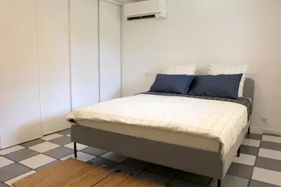 a bed in a bedroom with a checkered floor at VILLA ARVOR CANNES Appartement indépendant en bas de maison in Cannes