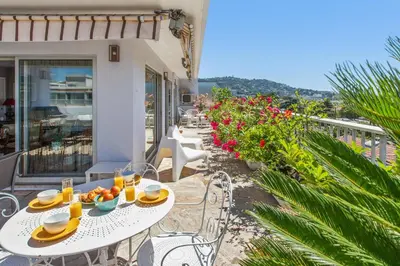 a table and chairs on the balcony of a house at Le Panoramique Croisette - Welkeys in Cannes