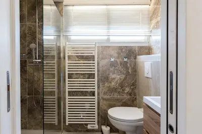 a bathroom with a toilet and a glass shower at Le Panoramique Croisette - Welkeys in Cannes