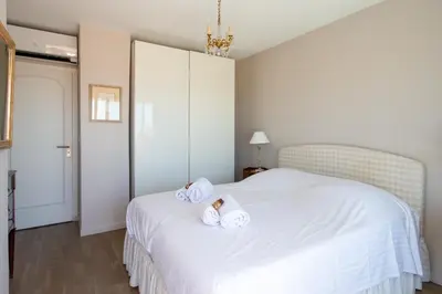 a bedroom with a white bed with towels on it at Le Panoramique Croisette - Welkeys in Cannes