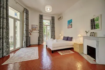a bedroom with a white bed and a fireplace at IMMOGROOM - Fully equipped -AC- near Palais des Festivals in Cannes