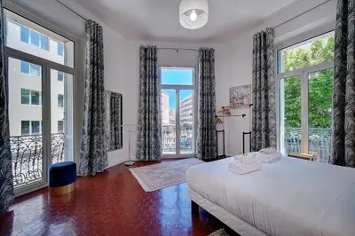 a bedroom with a large bed and large windows at IMMOGROOM - Fully equipped -AC- near Palais des Festivals in Cannes