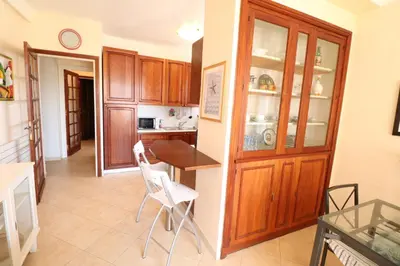a kitchen with wooden cabinets and a table and chairs at 1 Bedroom Henri IV on the Croisette 240 in Cannes