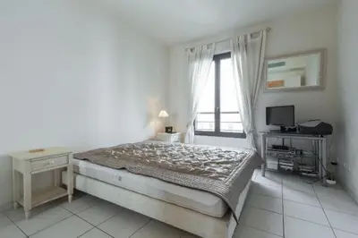 a bedroom with a bed and a desk and a window at Cannes centre 2mins from beach stunning 3-Bed Apt in Cannes